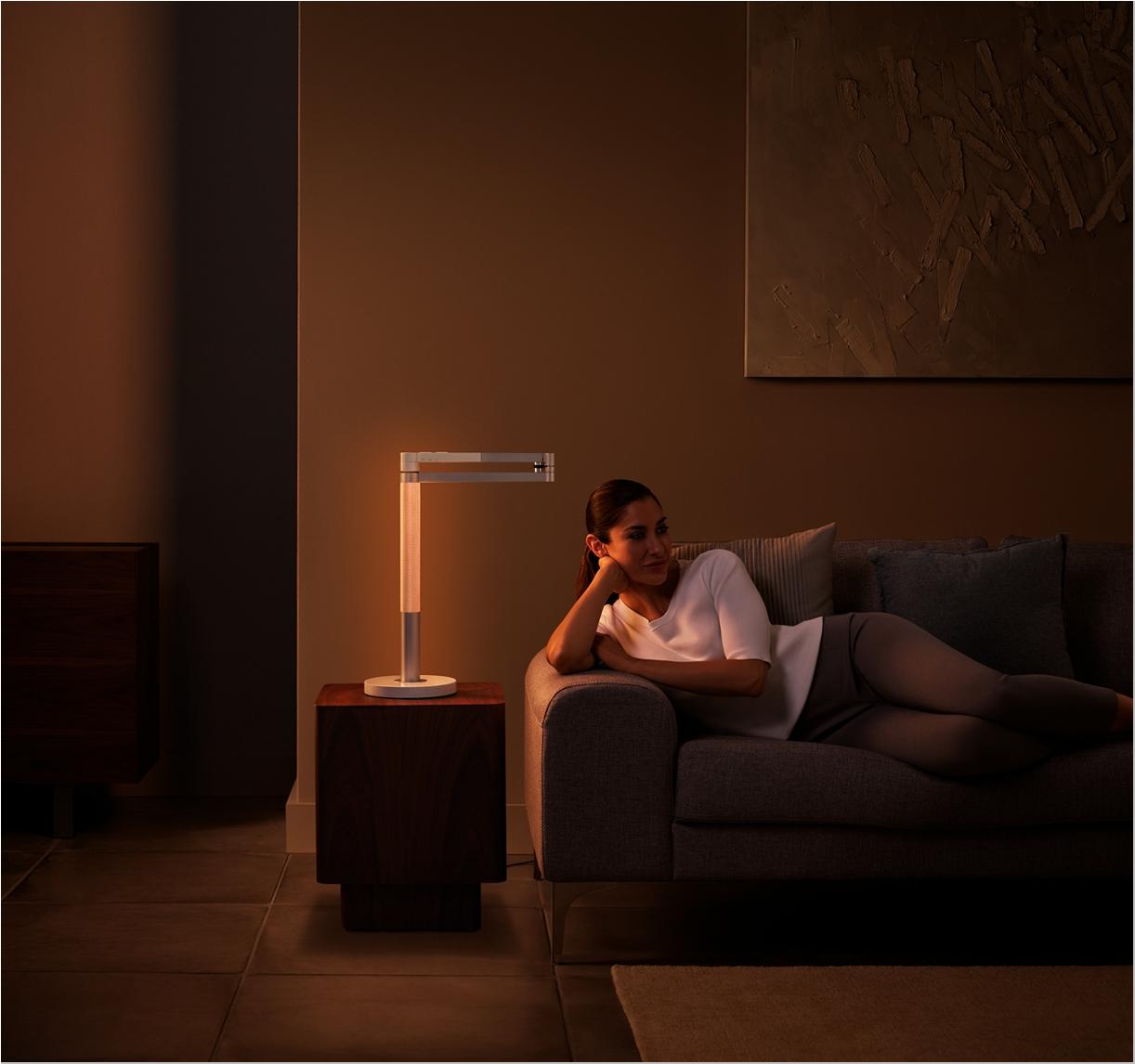 Woman relaxing comfortably with the Dyson Morph lighting.